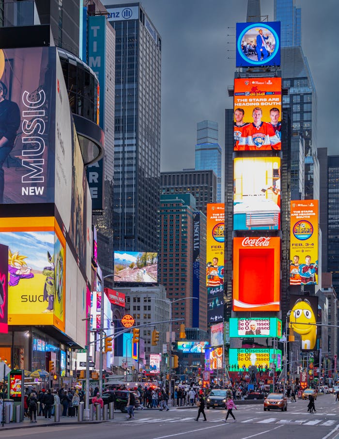 A bustling view of Times Square filled with bright, colorful billboards and lively street activity at night.